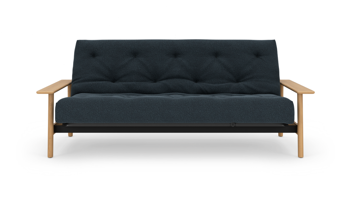 Mørkeblå 2-personers sofa med knap-quiltet polstring og lyse træarmlæn, frilagt på hvid baggrund, set lige forfra.