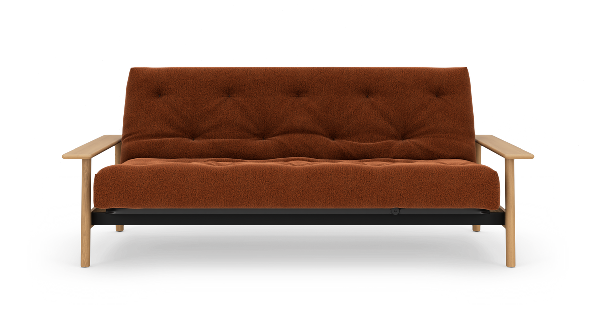 Rustrød, knapquiltet sofa med lys træramme og armlæn, frontvisning på hvid baggrund.