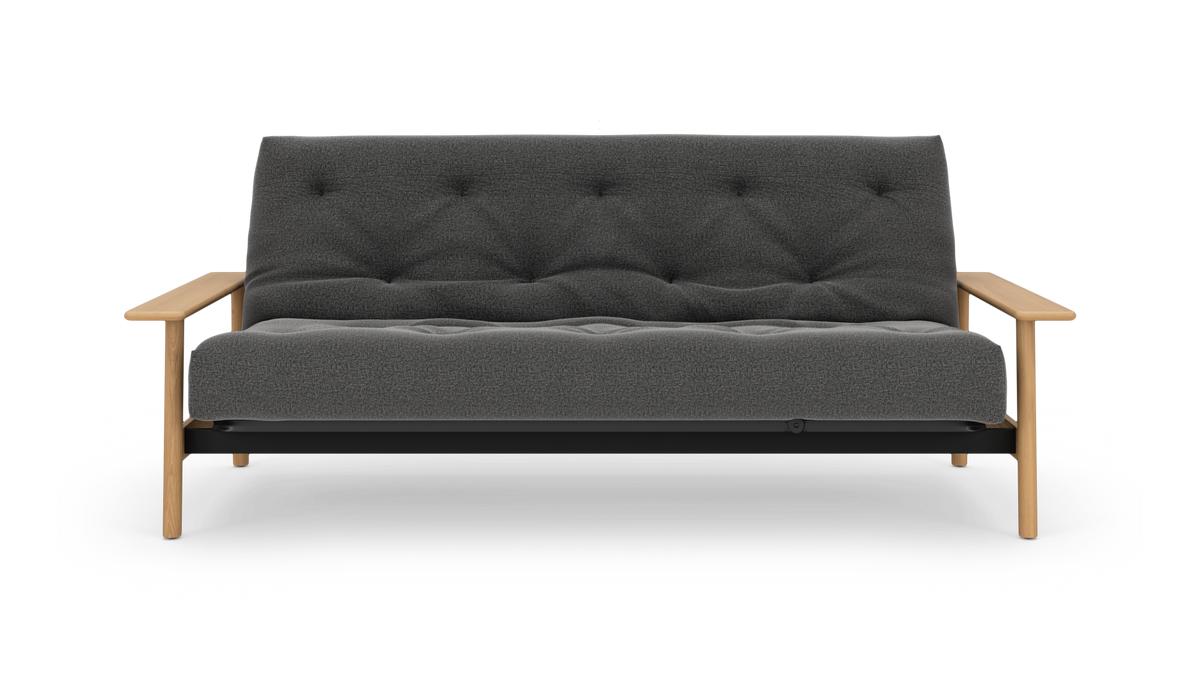 Grå to-personers sofa med knapquiltet polstring og lyse træarmlæn, frilagt mod hvid baggrund.