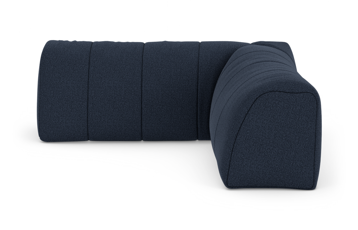 Mørkeblå rund modulsofa i stof – hjørnesektion set i vinkel på hvid baggrund.