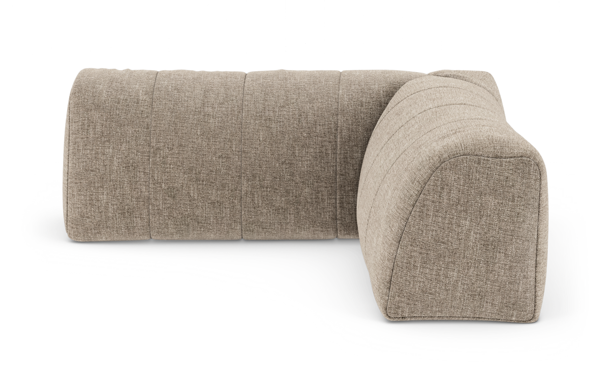 Beige modulsofa i stof med afrundede former, fotograferet mod hvid baggrund i let vinkel.
