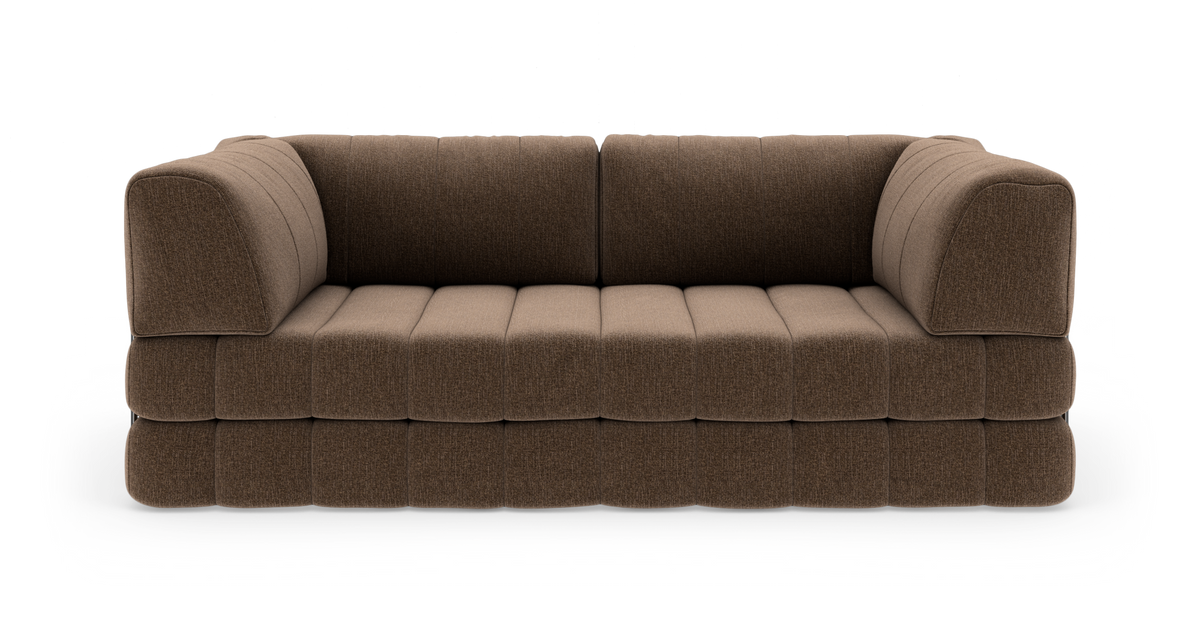 Brun, modulær 3-personers sofa med bløde, quiltede puder, frilagt mod hvid baggrund.