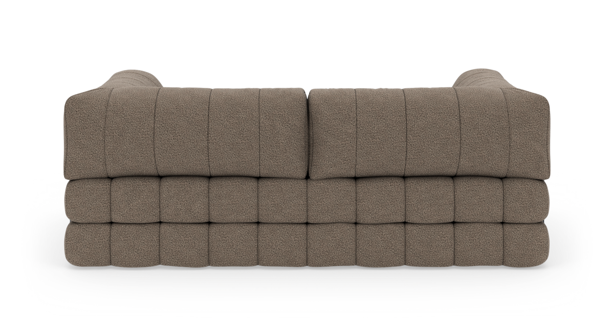 Bagfra visning af en modulær, beige/brun tuftet sofa på hvid studiebaggrund.