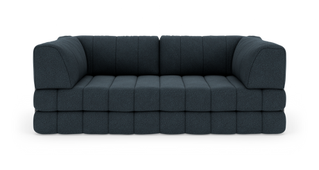 Modulsofa i mørkeblåt stof med lave, brede sædehynder, fotograferet lige forfra på hvid studiebaggrund.