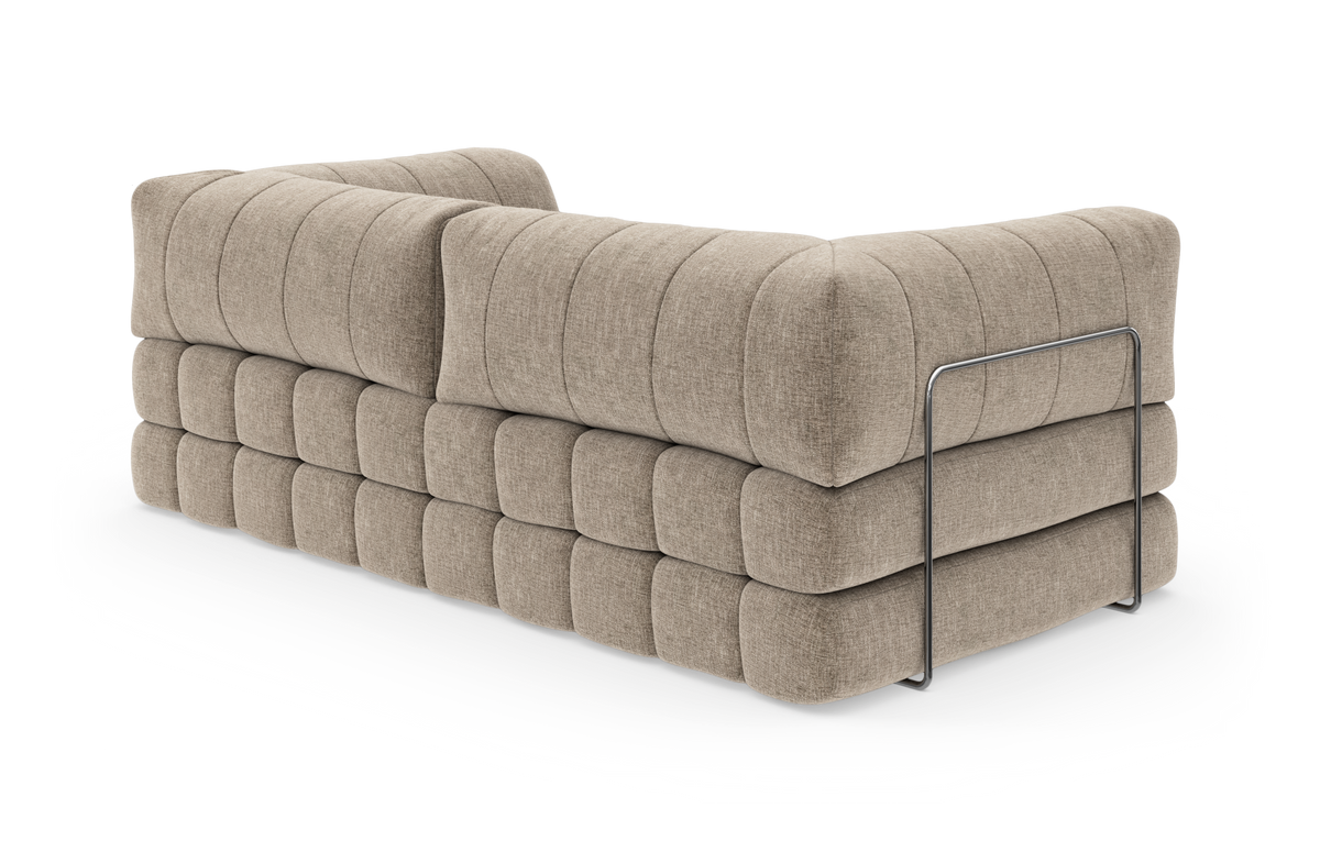 Beigefarvet modulsofa i stof med quiltet, puffet polstring og metalramme, set skråt bagfra.