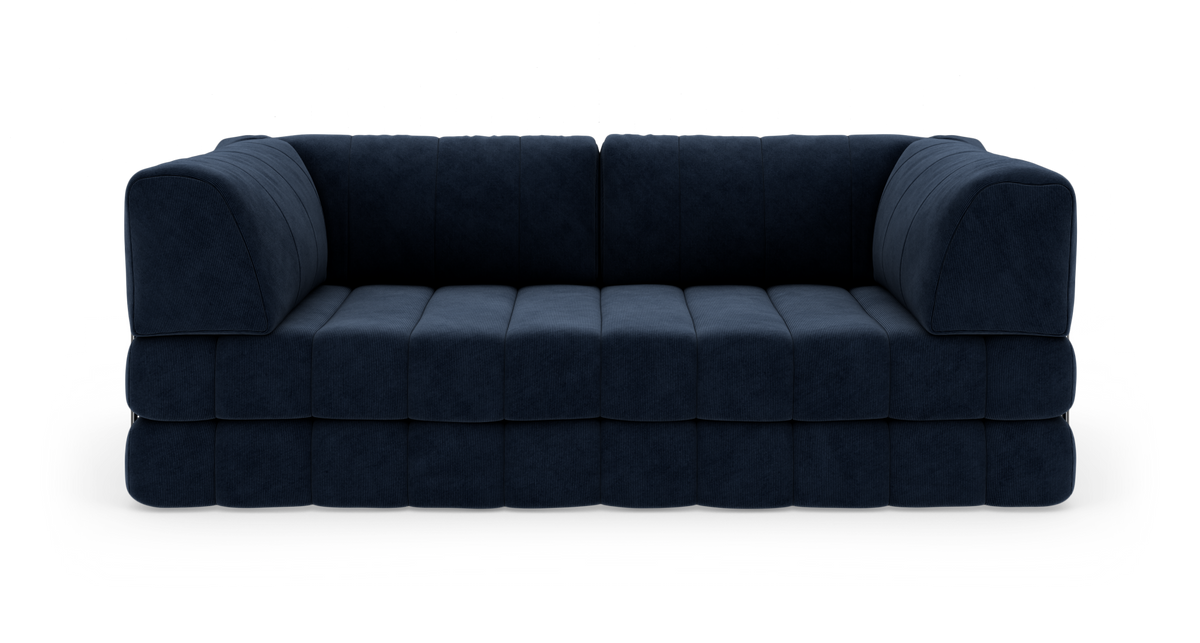 Mørkeblå modulsofa i plys/cordstof, set direkte forfra mod hvid baggrund.