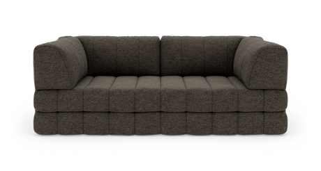 Modulsofa i mørkegrå/brun tekstil med dybe sæder og afrundede armlæn, set lige for i studiemiljø.