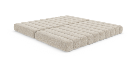 Beige modulær gulvmadras/futon med riflet polstring i fire sektioner, lav profil på hvid baggrund.