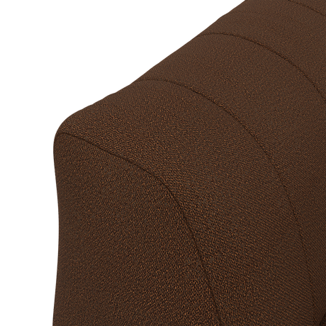 Nærbillede af brun tekstilbetrukket ryglæn på sofa eller lænestol med buet form og dekorative syninger.