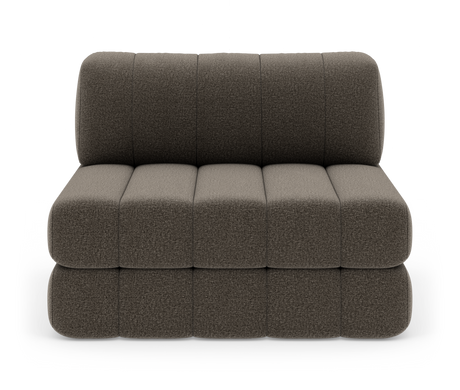 Modulsofa uden armlæn i mørkegrå tekstil med afrundede, blokquiltede sæde- og ryghynder, frilagt på hvid baggrund.