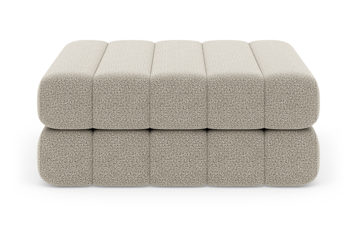 Beige modulær puf/ottoman i to lag med afrundede kanter på hvid studiobaggrund.