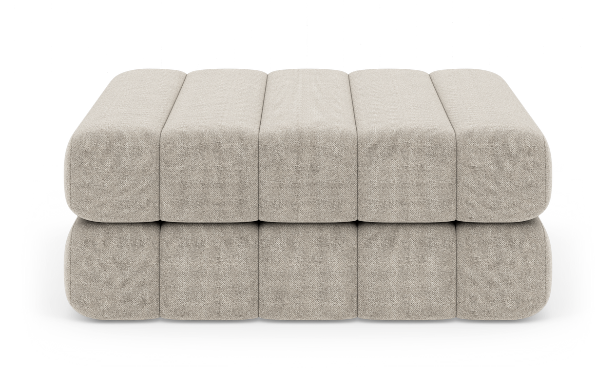 Beige modulær skammel/ottoman i to lag med afrundede blokke, frilagt på hvid baggrund.