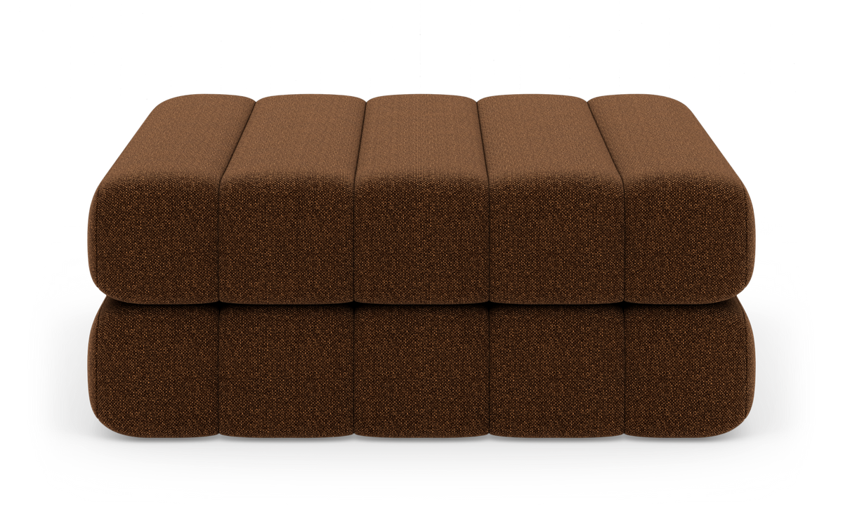 Brun polstret modul-ottoman i to lag med afrundede kanter, frontview mod hvid studiobaggrund.