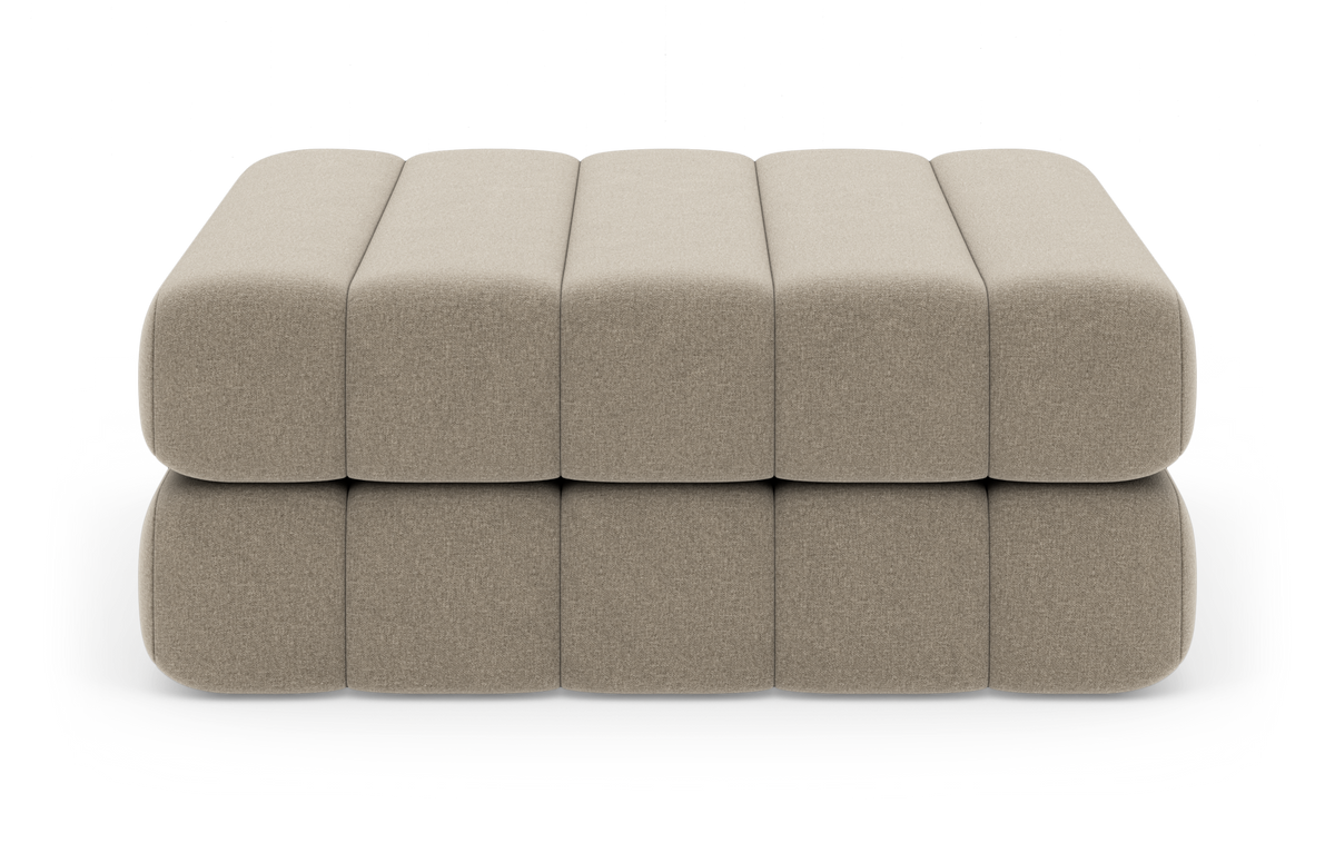 Beige modulær polstret ottoman/puf i to lag, set forfra på hvid studiebaggrund.