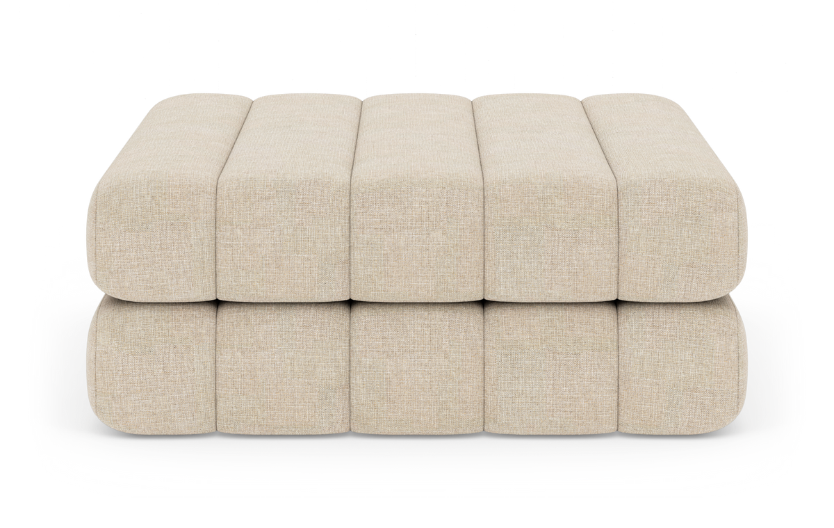 Beige modulær puf/ottoman med blødt afrundede sektioner i to lag, fotograferet i studie mod hvid baggrund.