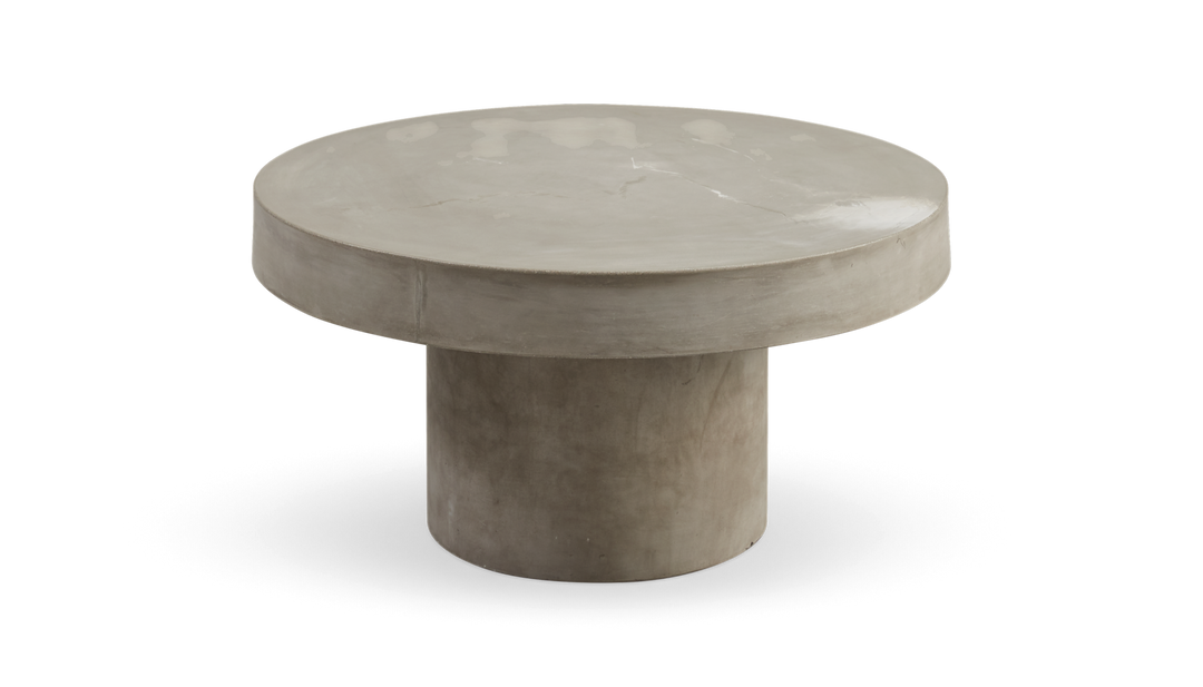Rundt sofabord i beton med tyk bordplade og cylindrisk søjlefod i grå, frilagt produktbillede.