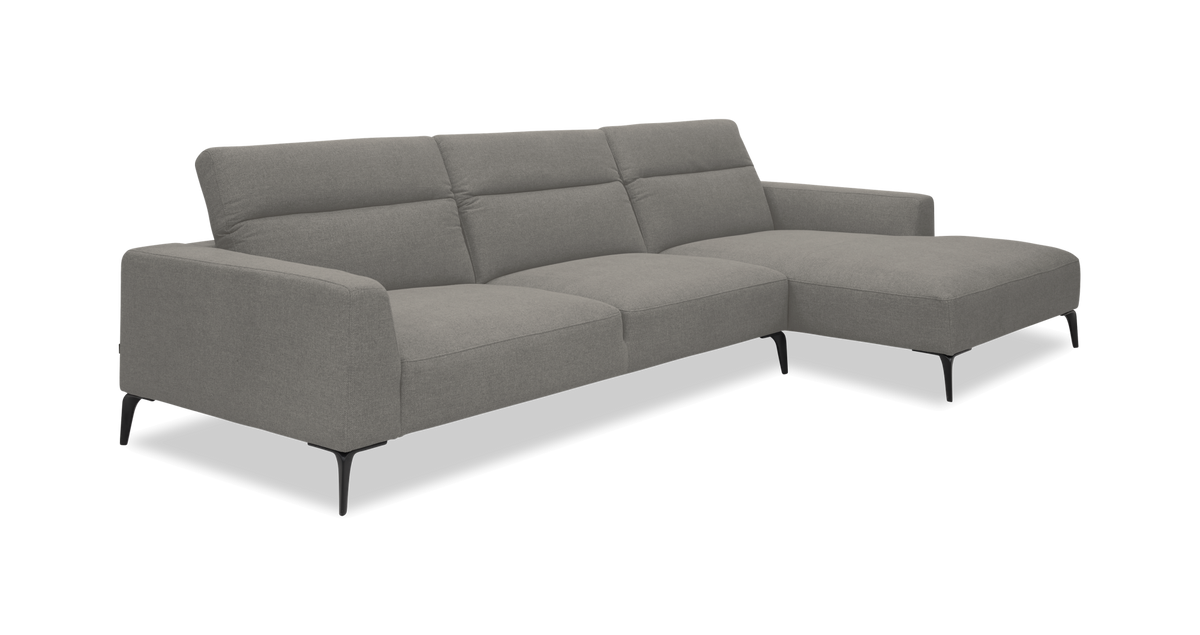 Grå hjørnesofa med chaiselong til højre på slanke sorte ben, frilagt på hvid baggrund.