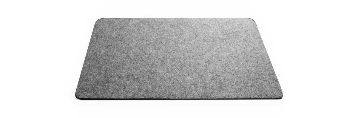 Gråt rektangulært filt-tæppe med afrundede hjørner på sort baggrund.