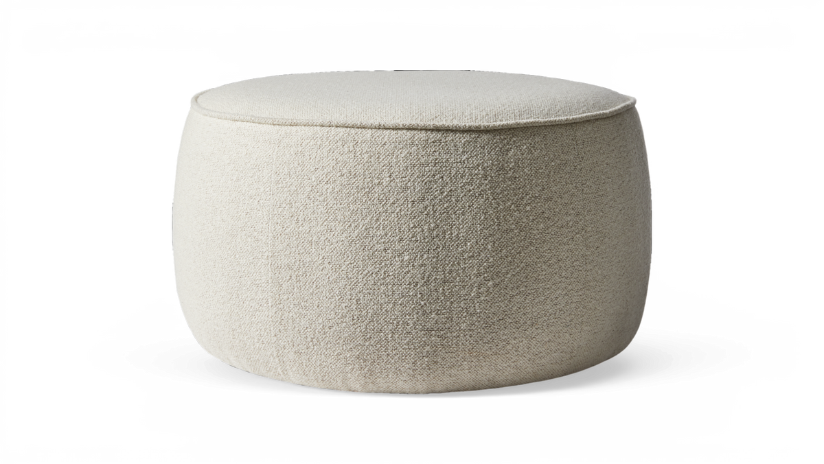 Beige, rund puf i boucléstof på sort baggrund.