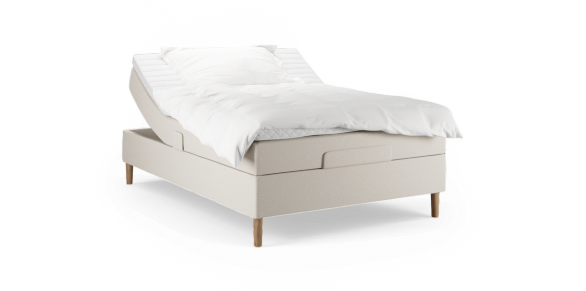 Justerbar seng i beige tekstil med træben, hvidt sengetøj og hævet hovedende.