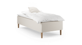 Enkelseng med beige polstret base, træben og hvidt sengetøj med pude._ps