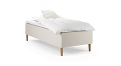 Enkelseng med beige polstret base, træben og hvidt sengetøj med pude.