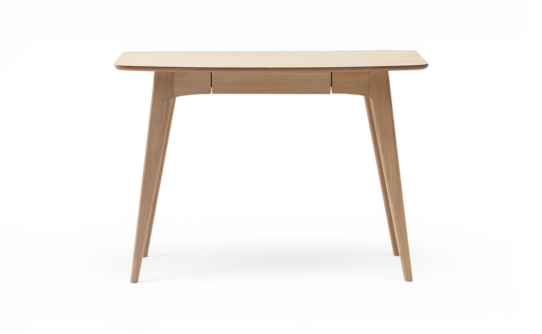 Lyst skrivebord/konsolbord i eg med koniske ben og smal midtskuffe, fritlagt mod hvid baggrund, frontvisning.