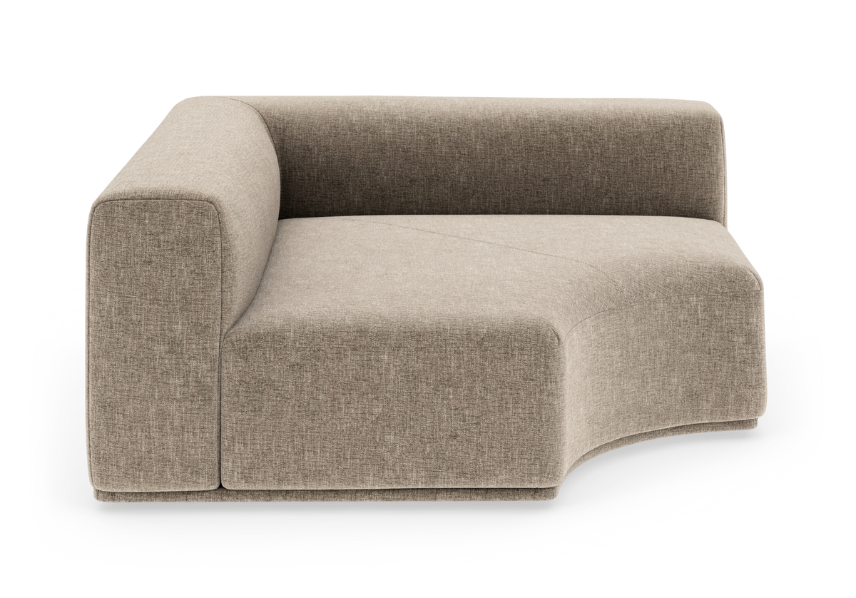 Beige modulsofa med venstre armlæn og blødt buet chaiselong, frilagt på hvid baggrund.