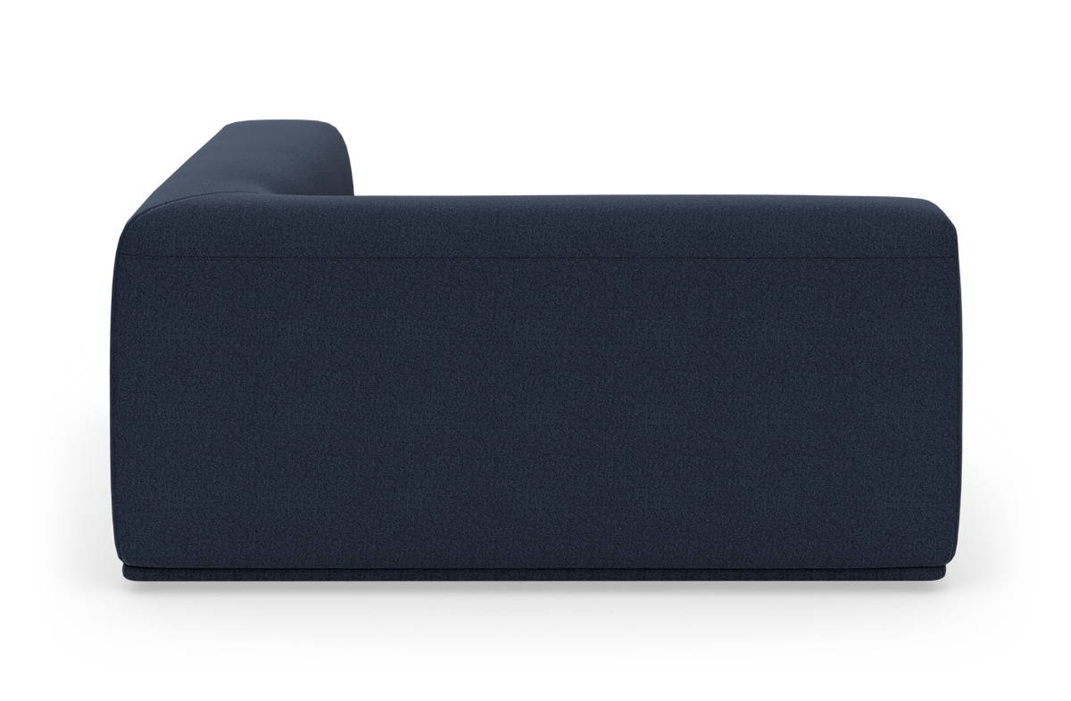 Mørkeblå, minimalistisk sofa set fra siden mod hvid baggrund.