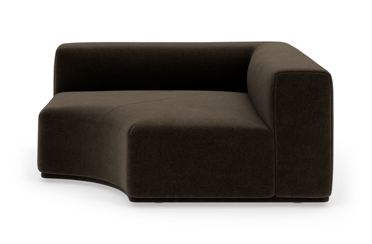 Modulsofa i mørkebrun tekstil med afrundet venstrekurvet sæde og højt armlæn på højre side, frilagt på hvid baggrund.