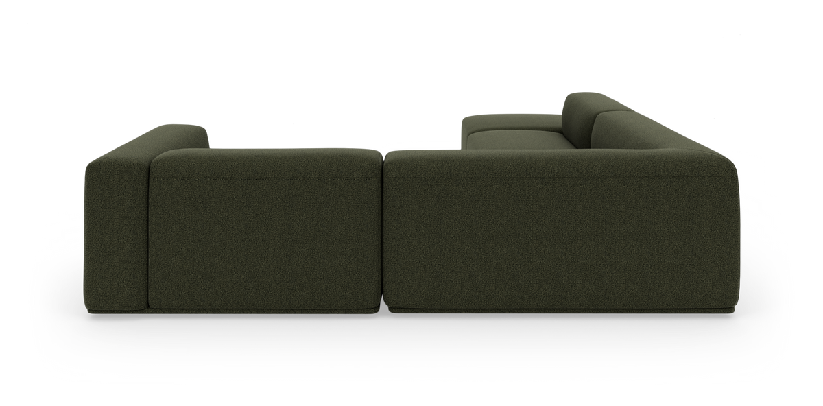 Grøn modulær hjørnesofa med chaiselong og bløde kubiske former på sort baggrund.