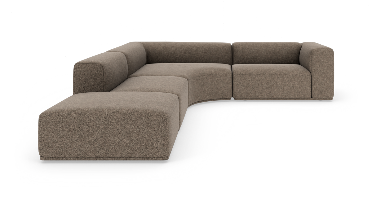 Modulær L-formet hjørnesofa i beige bouclé, lav og afrundet, frilagt på hvid baggrund.