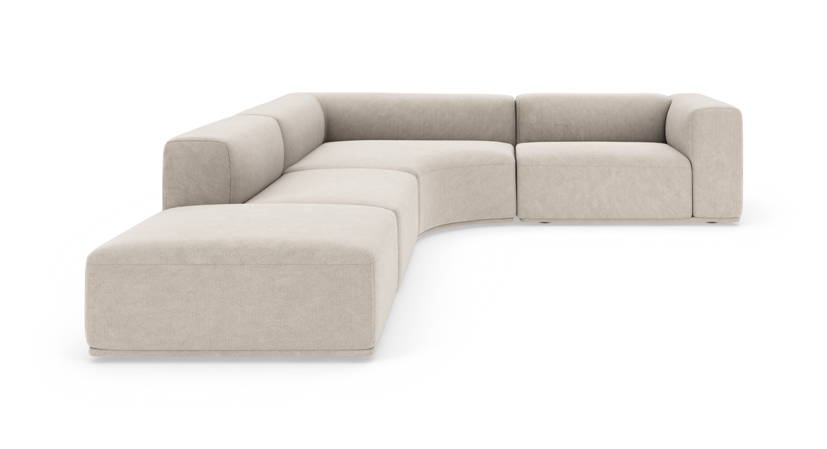 Beige modulsofa i L‑form med rundet hjørne og bred chaiselong til venstre, frilagt på hvid baggrund.