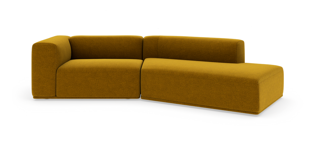 Modulær L-formet sofa i sennepsgul stofpolstring på hvid studiebaggrund.