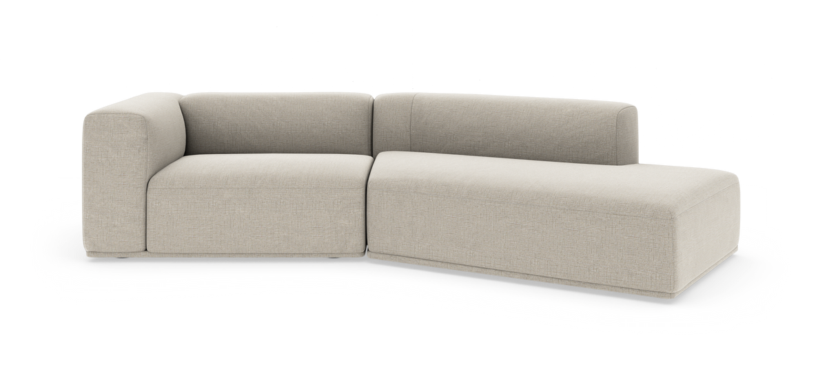 Beige modulsofa i L‑form med høj ryg og afrundede hjørner, frilagt på hvid baggrund.