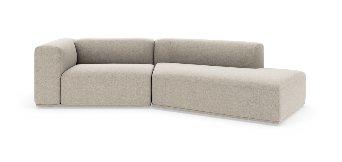 Beige L-formet modulsofa med chaiselong og afrundede former på hvid studiobaggrund.