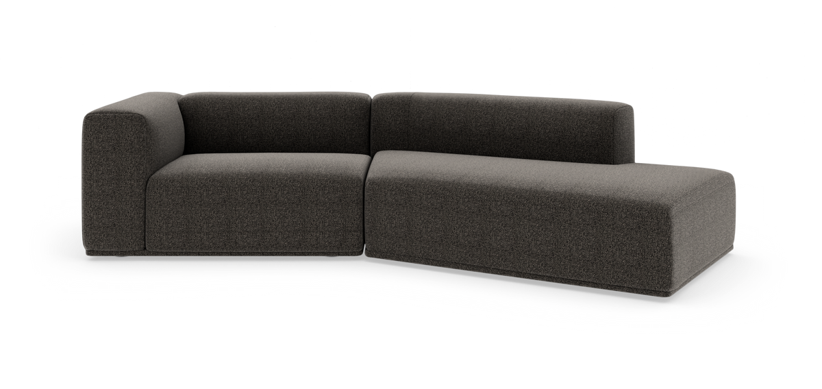 Modulær mørkegrå hjørnesofa med chaiselong til højre mod hvid studiebaggrund.