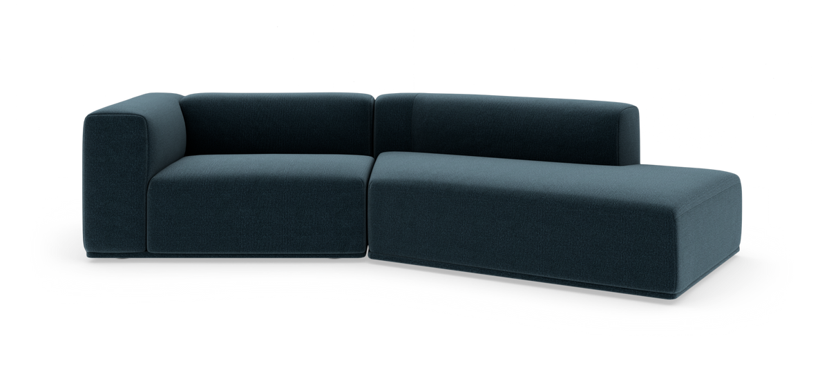 Modulsofa i mørk petrolblåt stof med højrevendt chaiselong, vist i studie på hvid baggrund.