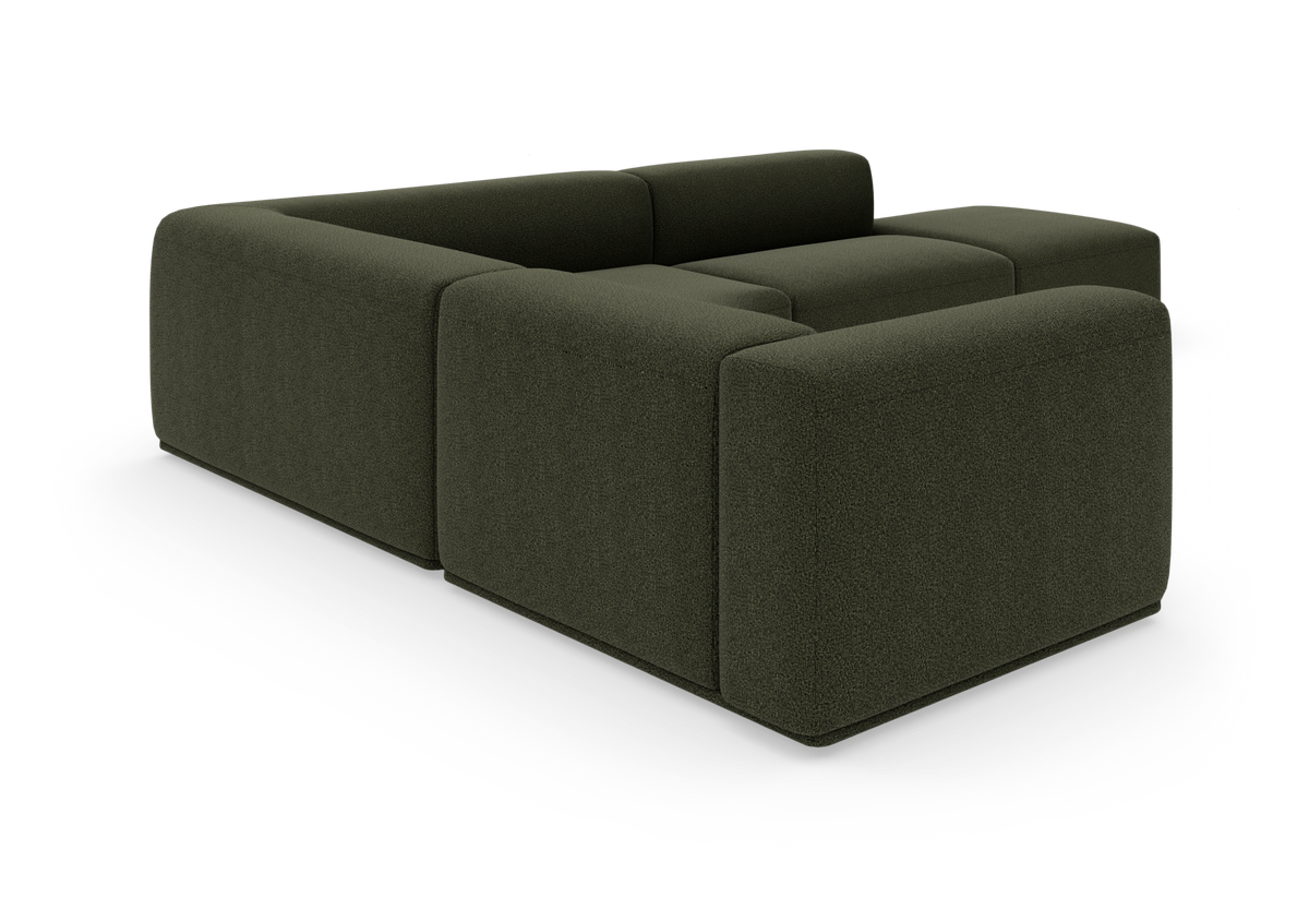 Mørkegrøn modulsofa i kubistisk design set skråt bagfra på hvid baggrund.