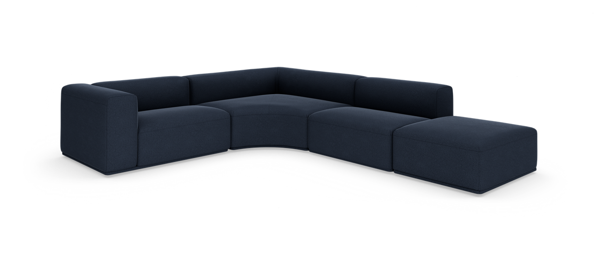 Mørkeblå modulhjørnesofa i L-form med ottoman på højre side, fritstående på hvid baggrund.