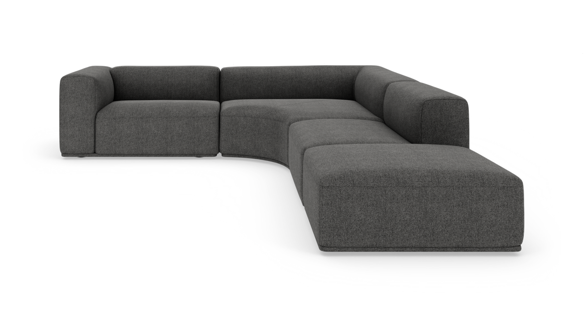 Mørkegrå modulsofa i L‑form med afrundede hjørner, vist frilagt på hvid baggrund.