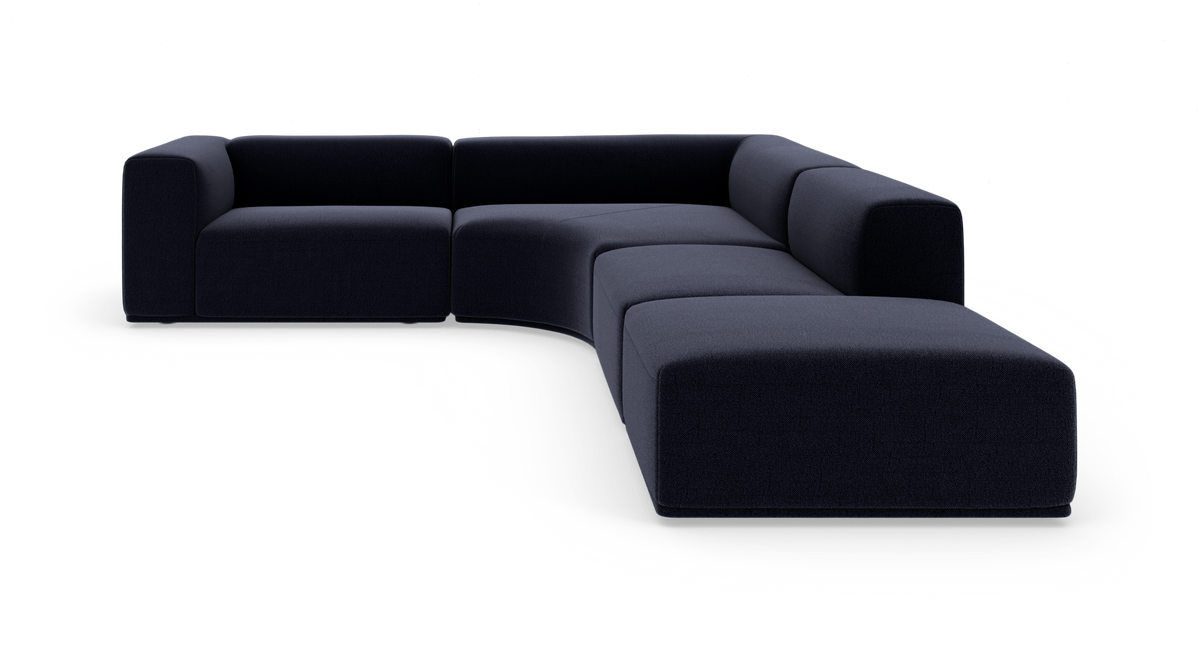 Modulopbygget mørkeblå L-formet hjørnesofa i tekstil med afrundet chaiselong, fotograferet i studio.