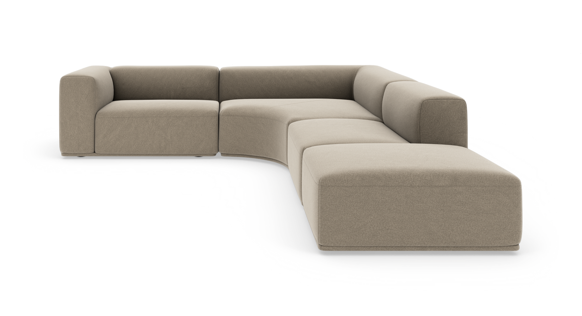 Modulær hjørnesofa i beige stof med bløde, afrundede former og bred chaiselong til højre, frilagt på hvid baggrund.