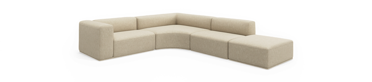 Beige modulsofa i L‑form med afrundet hjørnesektion og afsluttende puff, frilagt på sort baggrund.