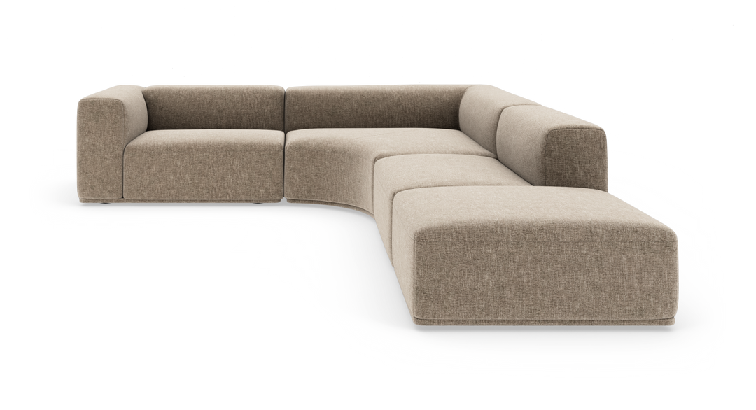 Modulsofa i beige stof, L-form med afrundet hjørnesektion og bred chaiselong.