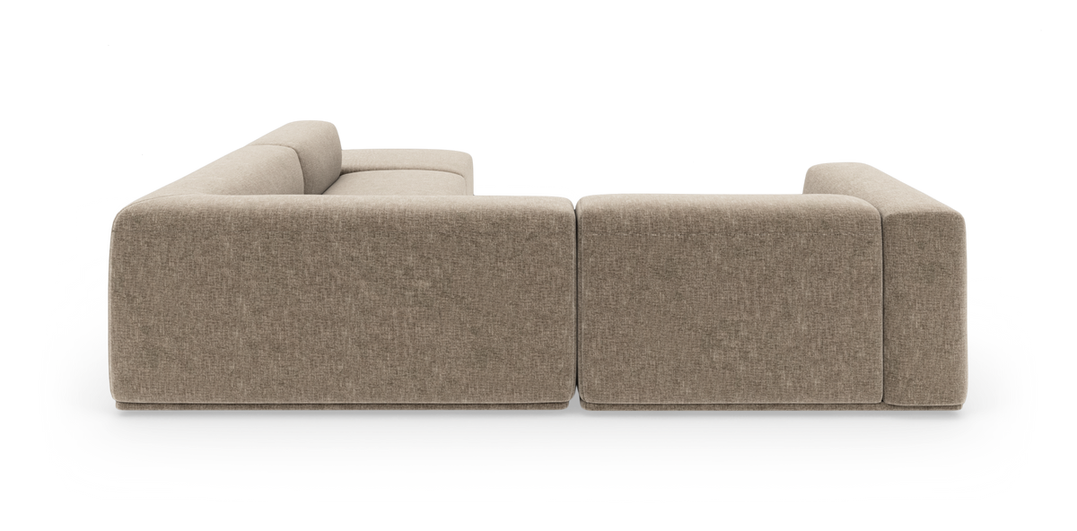 Beige modulsofa med buet hjørne og chaiselong, frilagt på sort baggrund.