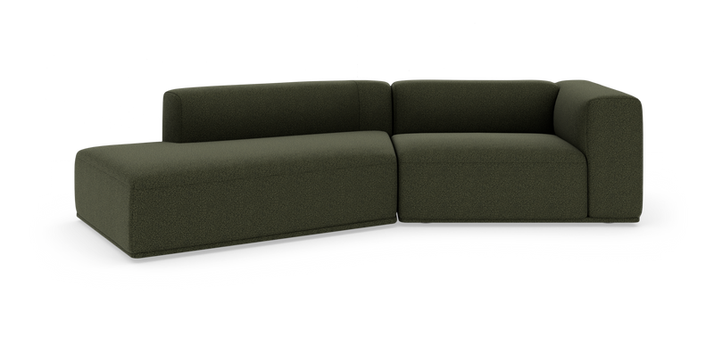 Mørkegrøn modulsofa i L‑form på hvid studiobaggrund._ps