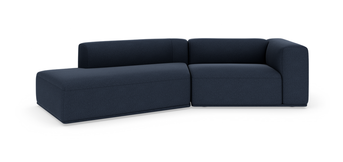 Modulsofa i mørkeblåt stof, L-formet, fritlagt på hvid baggrund.