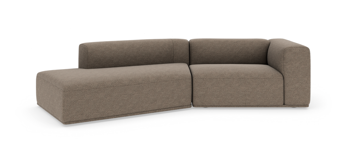 Modulær L‑formet sofa i brun‑beige bouclé med afrundede kanter, vist på hvid studiebaggrund.