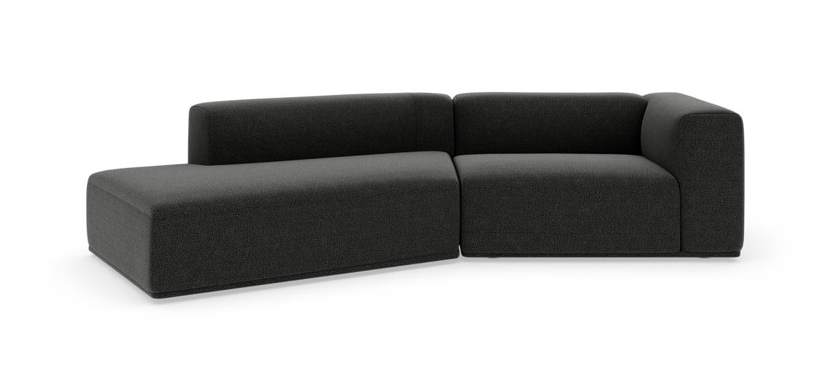 Modulær mørkegrå hjørnesofa i tekstil, fotograferet i studie på hvid baggrund.